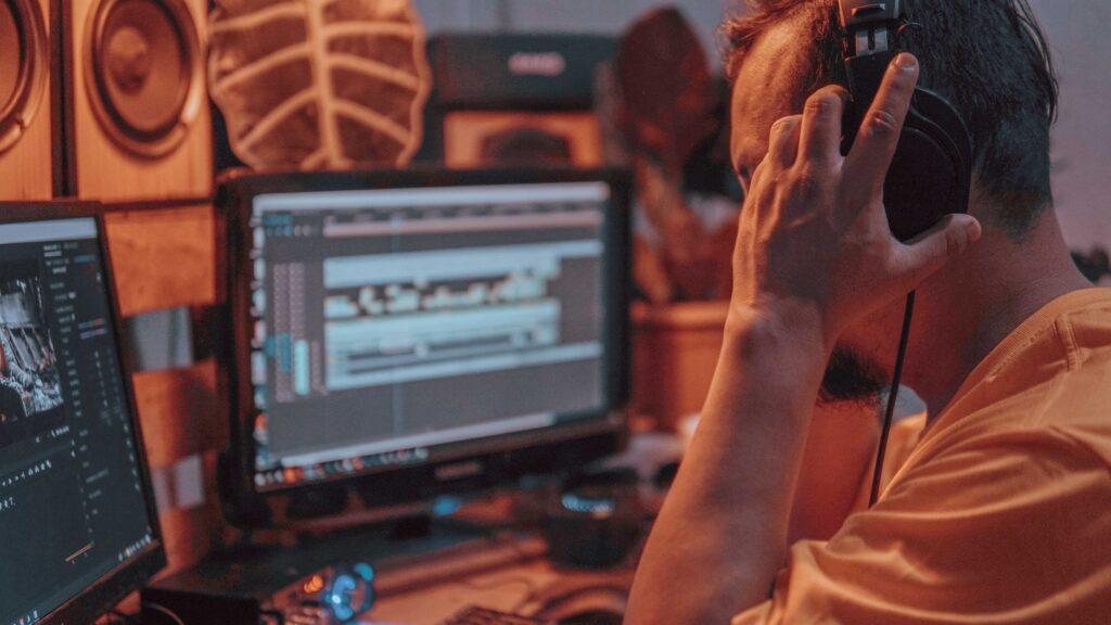 Suno AI Review 2026: Can This AI Music Generator Create Real Indian Songs? Close-up of an audio engineer editing sound on a computer in a recording studio.