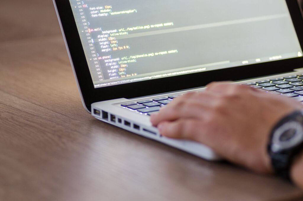 Bolt.new vs Lovable vs v0 in 2026: Which AI No-Code App Builder Should Indian Developers Choose? Developer coding on laptop with HTML code screen for no-code app builder comparison