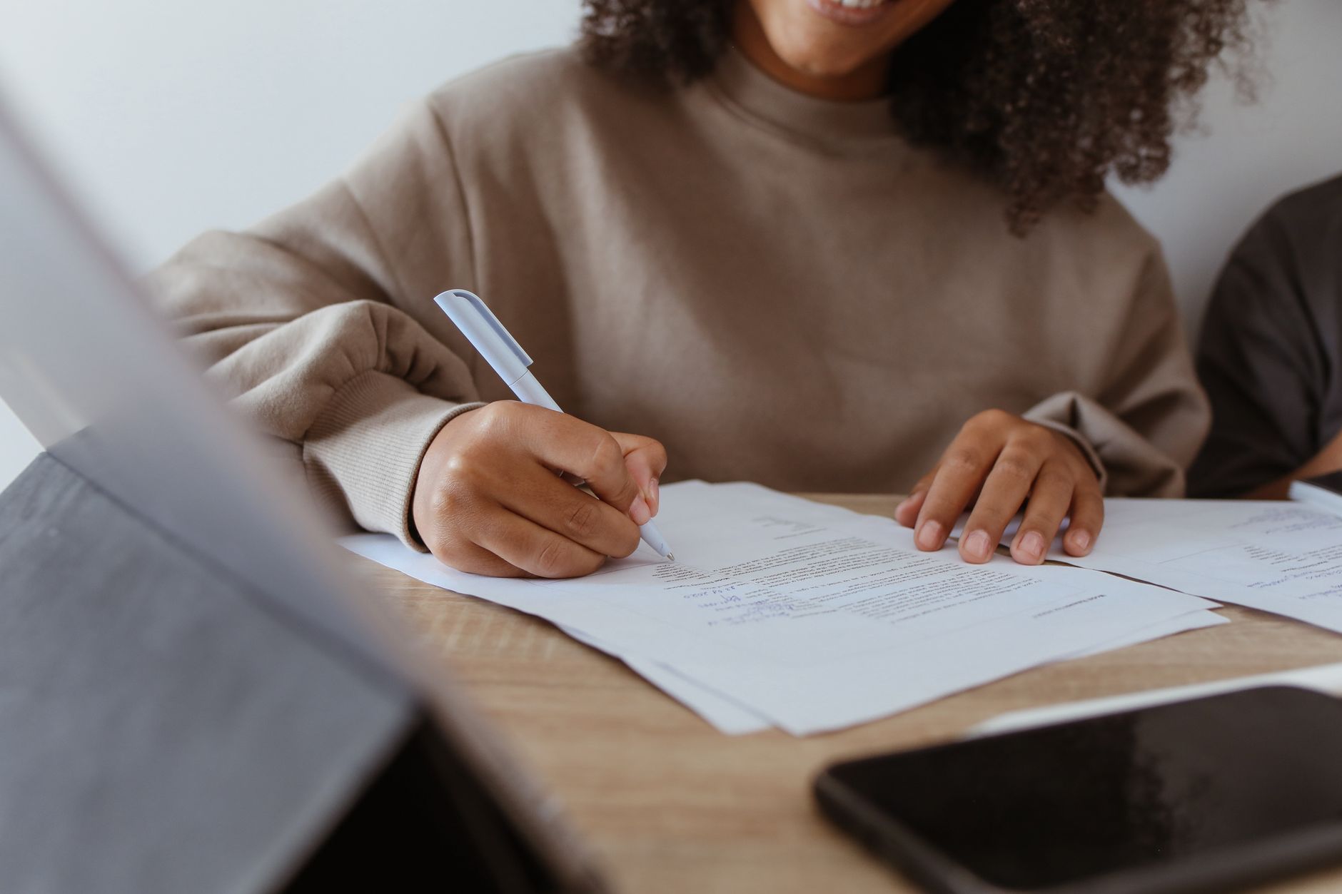 Student writing and proofreading document on laptop