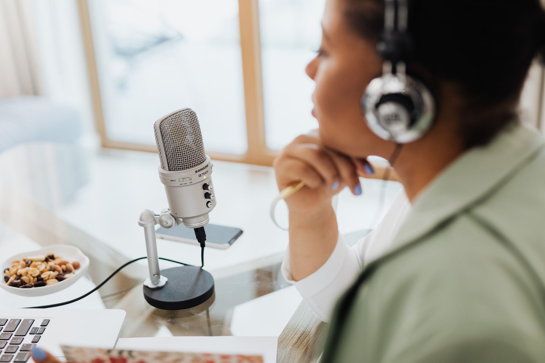 Woman podcasting using AI transcription tool on laptop at home India 2026