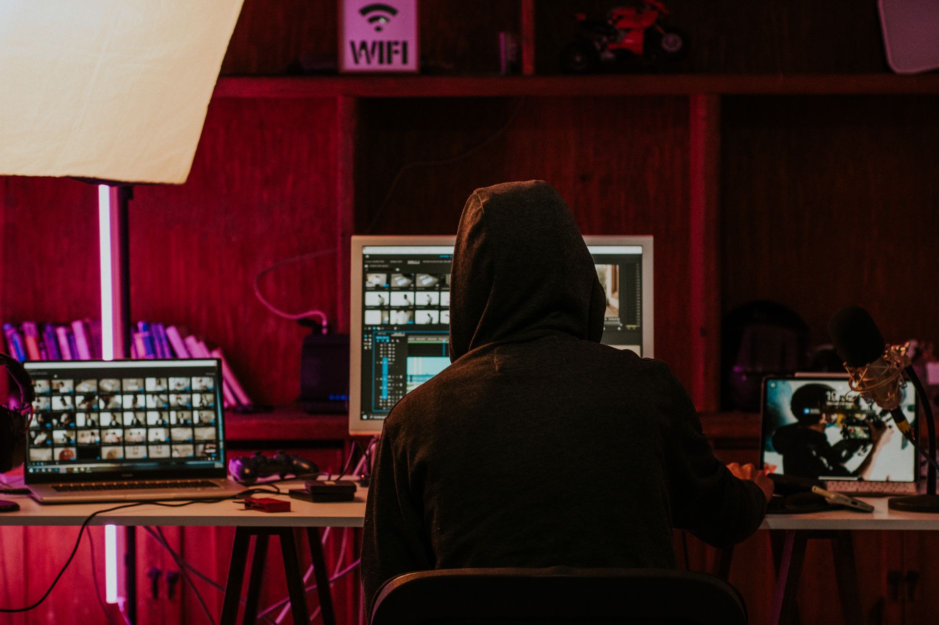 Video creator editing content on multiple screens with professional setup