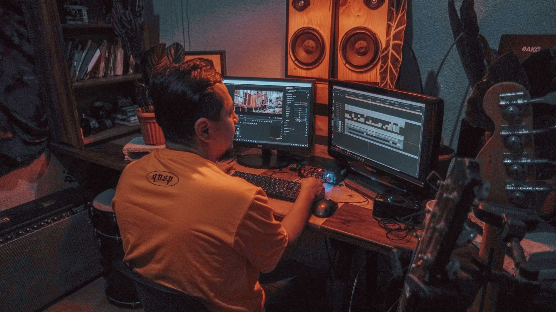 Person editing video footage on dual monitors in home studio setup