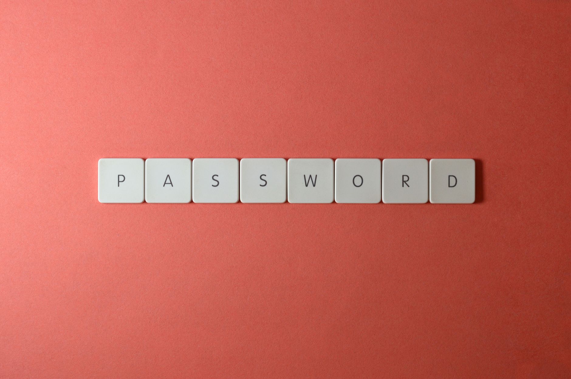 Online Privacy Guide 2026: Essential Toolkit Password security concept with keyboard tiles spelling PASSWORD on a coral background