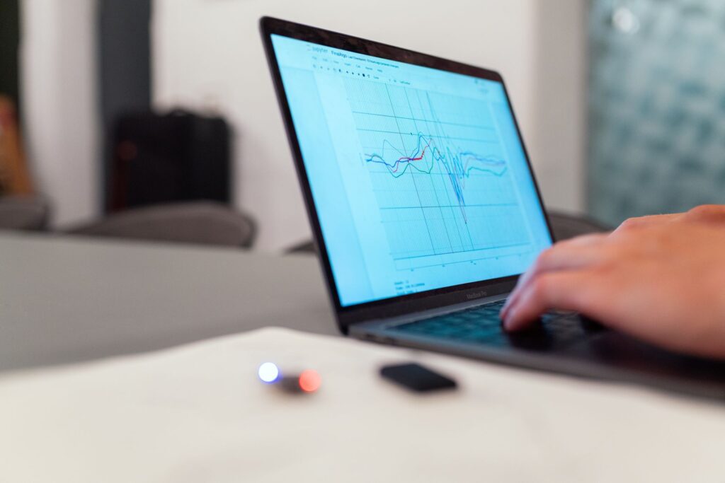 Person working on laptop analyzing data graphs for AI research and business intelligence