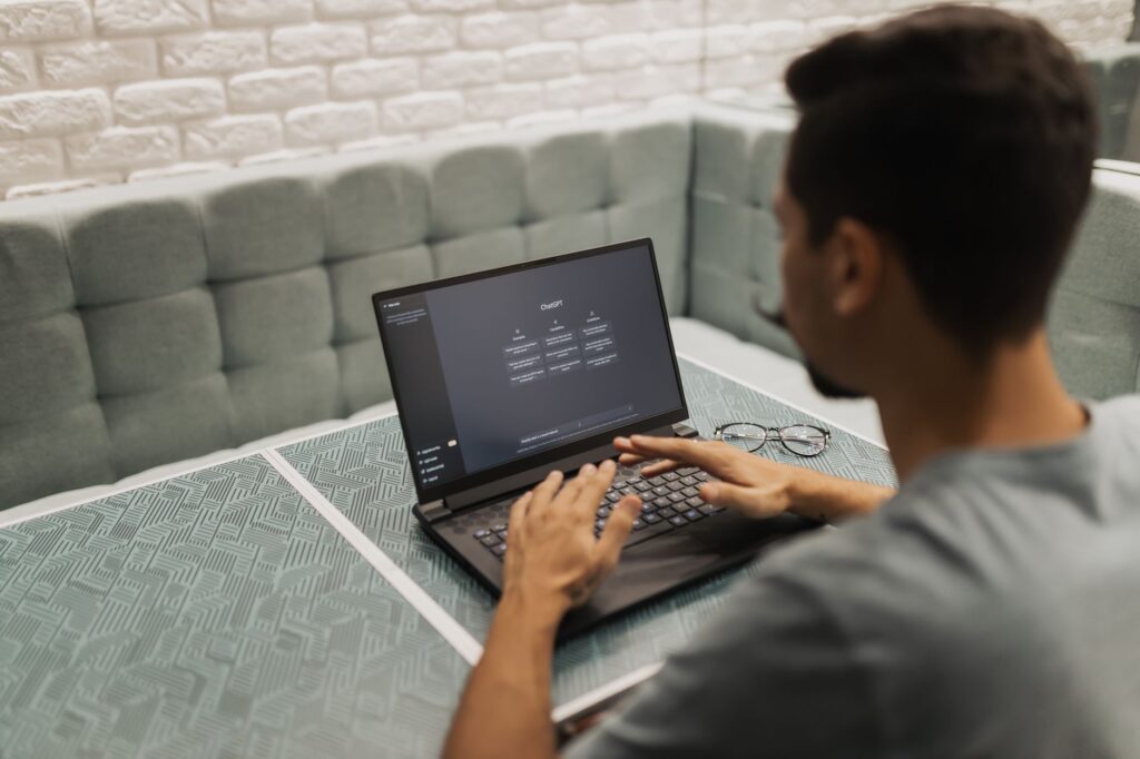 Best AI Writing Tools for US Content Teams 2026 Person using laptop with ChatGPT interface visible — AI writing tool in use at a modern workspace