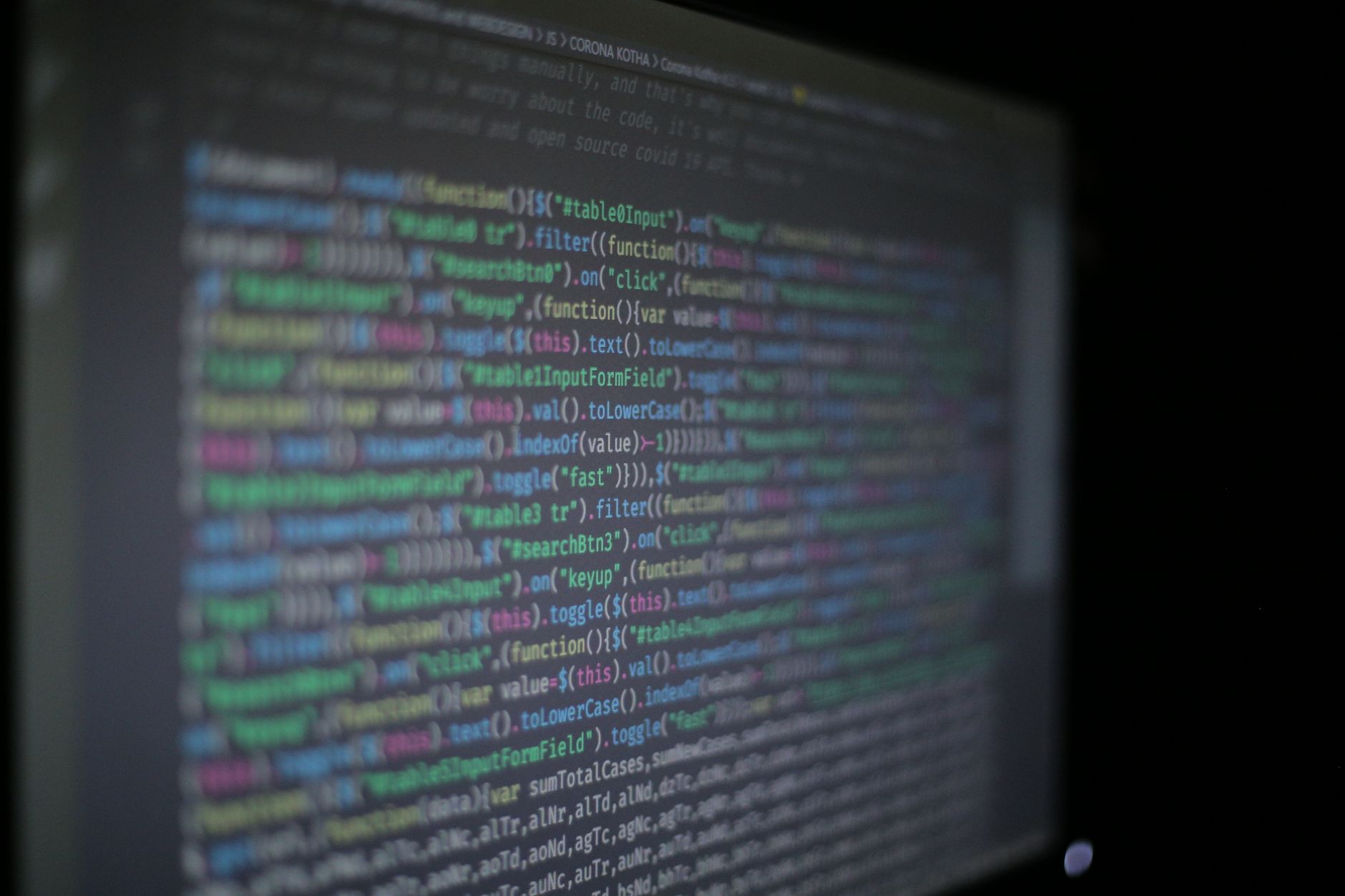 Close-up of colorful programming code on a blurred computer monitor