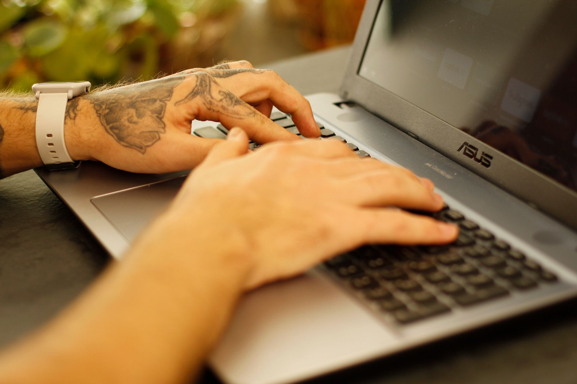 Person typing on laptop keyboard working with AI productivity tools
