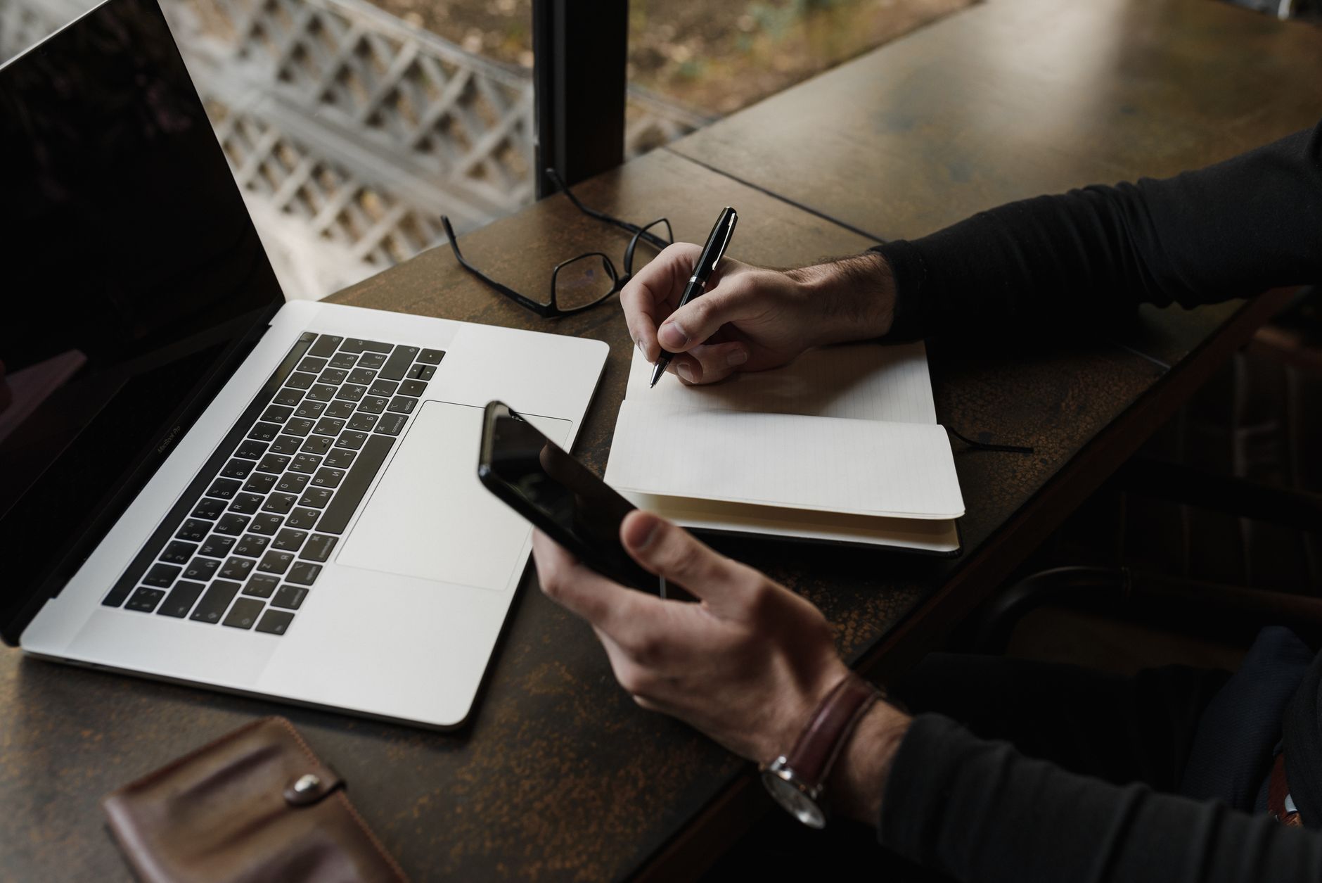 AI Note-Taking Apps 2026: Obsidian vs Mem A business professional multitasking with a laptop, smartphone, and notebook in a modern workspace