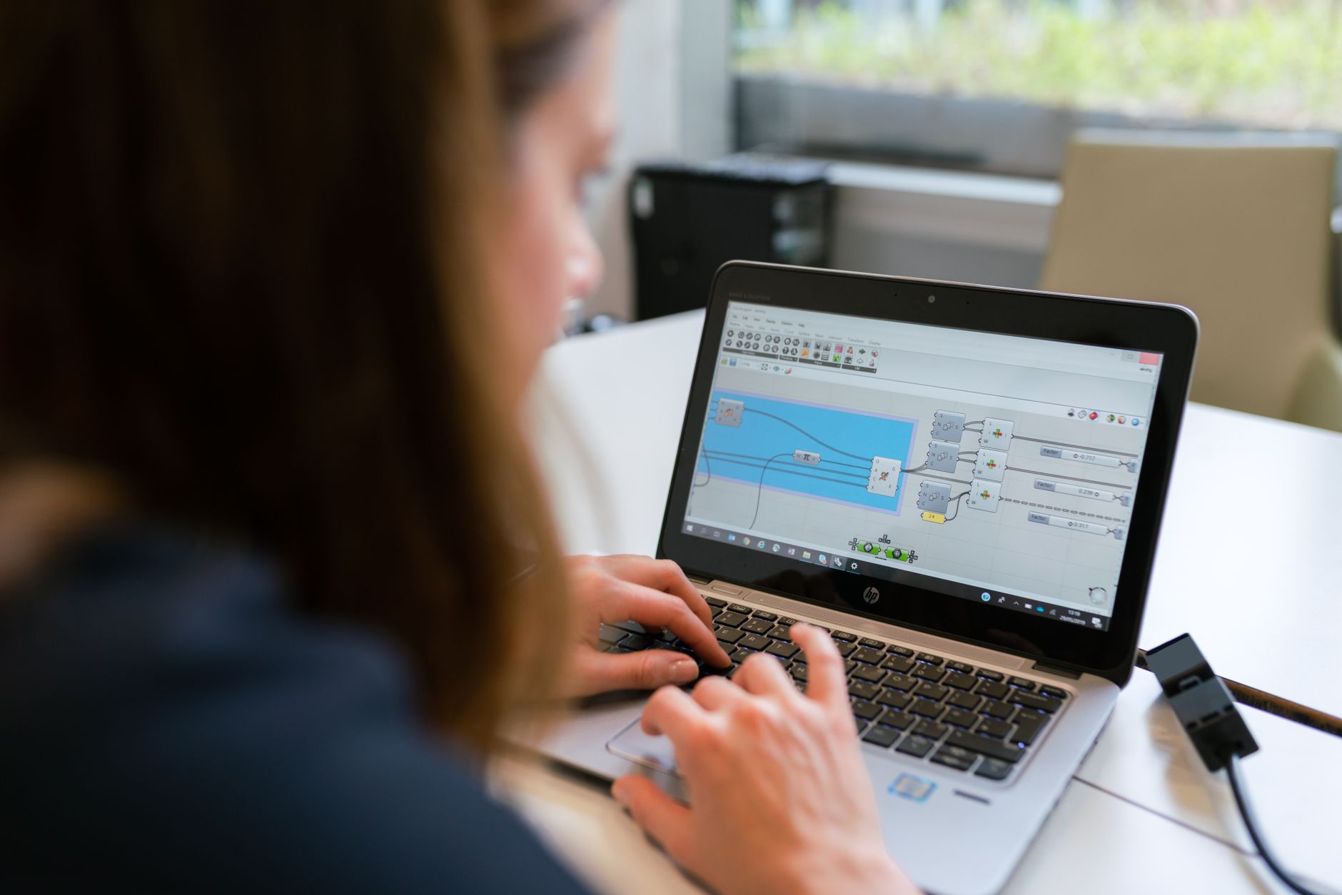 Best Automation Tools 2026: Zapier, Make, n8n A woman engineer focuses on software analysis using a laptop indoors.