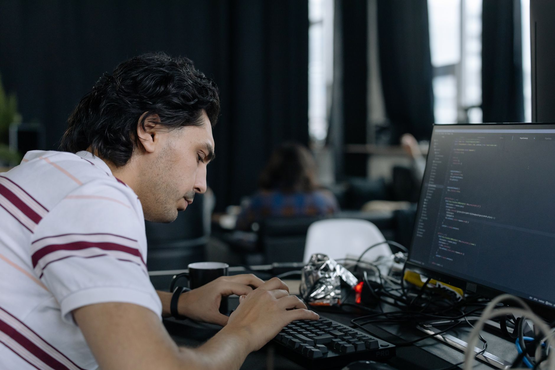 Developer typing code at a workstation — productivity with AI code editors